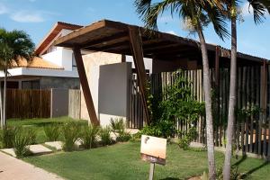a house with a sign in the front yard at Condominio Uhane Luxury Villas in São Miguel do Gostoso