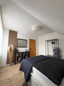 a bedroom with a black bed and a mirror at Ferienwohnung zum Pferdeblick in Bad Bentheim
