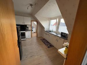 a kitchen with white cabinets and a large window at Ferienwohnung zum Pferdeblick in Bad Bentheim