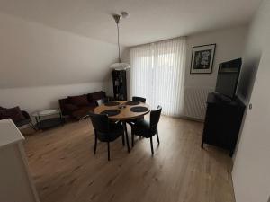 a dining room table and chairs in a living room at Ferienwohnung zum Pferdeblick in Bad Bentheim