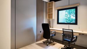 an office with two chairs and a desk and a window at Metrolux By ZG in Ho Chi Minh City