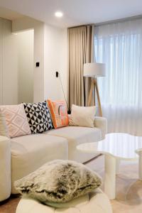 a living room with a white couch and a table at Metrolux By ZG in Ho Chi Minh City