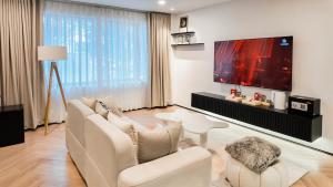 a living room with a white couch and a flat screen tv at Metrolux By ZG in Ho Chi Minh City