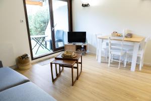 a living room with a couch and a table and a dining room at Studio Les Epicéas in Boersch