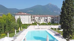 a resort with a swimming pool in front of a building at Corte Fasanella 31 - Gardagate in Toscolano Maderno
