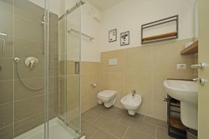 a bathroom with a shower and a toilet and a sink at Corte Fasanella 31 - Gardagate in Toscolano Maderno +23 photos