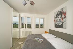 a bedroom with a bed and two windows at Corte Fasanella 31 - Gardagate in Toscolano Maderno