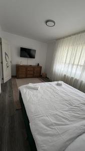a bedroom with a white bed and a flat screen tv at Luxury Lion Crib2 in Bacău