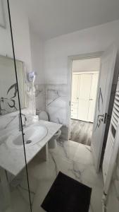 a white bathroom with a sink and a mirror at Luxury Lion Crib2 in Bacău