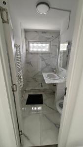 a white bathroom with a sink and a mirror at Luxury Lion Crib2 in Bacău