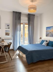 a bedroom with a blue bed and a table at Favola Guesthouse Affittacamere in Nettuno