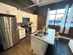a kitchen with a stainless steel refrigerator and a sink at Studio Apt King Bed Full Kitchen By KeenStays in Cape Girardeau