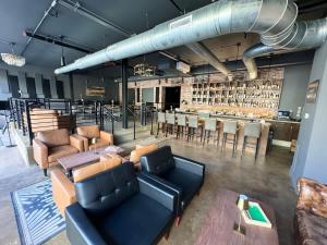 a room with couches and a bar in the background at Studio Apt King Bed Full Kitchen By KeenStays in Cape Girardeau +6 photos
