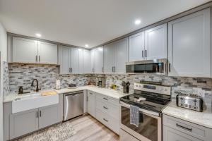 a kitchen with white cabinets and white appliances at Spacious Bartlett Condo w/ Balconies & Pool! in Bartlett