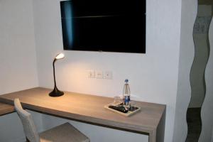 a desk with a television and a lamp on it at Brit Hotel Alghotel in Cancale
