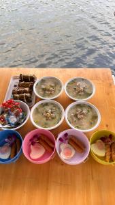 a group of bowls of food on a table near the water at แพบ้านแม่ in Ban Tha Ta On