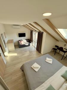 a attic room with a bed and a couch at Cloud9 Airport Suites in Močići
