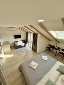 a attic room with a bed and a couch at Cloud9 Airport Suites in Močići +8 photos