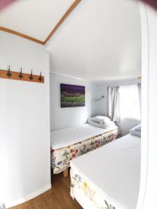two beds in a room with white walls at Stuga 11 Dalskärs camping in Bergkvara +37 photos