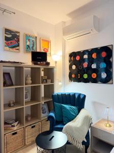 a living room with a blue chair and a book shelf at Old Town Vinyl Retreat near the Cathedral with retro vibes in Iaşi