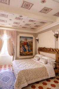 a bedroom with a bed with a painting on the wall at Palazzo Lari Sarzana - Historic Boutique Rooms in Sarzana