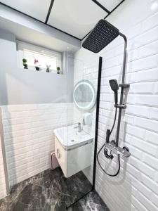 a white bathroom with a sink and a shower at Студио за гости АВАНГАРД in Gabrovo