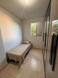 a small bedroom with a bed and a window at Apartamento prático e aconchegante - 5 min do Centro in Catanduva +4 photos