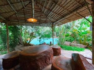 a group of logs sitting under a pavilion at River tales ริเวอร์เทลส์แก่งกระจาน in Phetchaburi