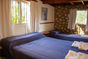 two blue beds in a room with two windows at Posada de Nono in Nono +204 photos