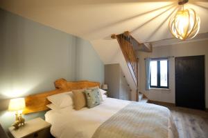 a bedroom with a large white bed and a window at The Plough Inn in Stalisfield