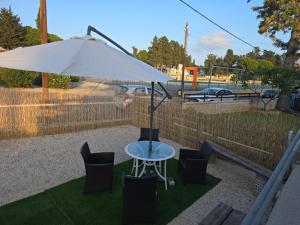 a table with chairs and an umbrella on the grass at Elias Apartment in Kissonerga