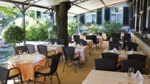 ein Restaurant mit weißen Tischen und Stühlen und Tischsuche in der Unterkunft Unique Hotel Innere Enge in Bern + 42 Fotos