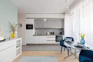 a kitchen with a glass table and blue chairs at Waterfront Luxury Residence - Paid Parking Option in Budapest