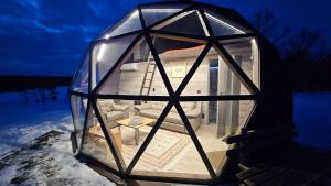 a glass igloo with a living room in it at Trys su puse upės in Dzidai