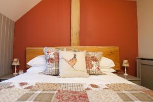 a bed with a wooden headboard and pillows on it at The Plough Inn in Stalisfield