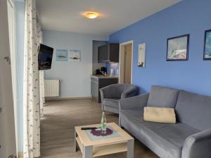 a living room with a couch and a table at Suite Hotel Villa Erika in Borkum