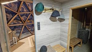 a bathroom with a walk in shower next to a wall at Trys su puse upės in Dzidai
