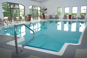 a large swimming pool with chairs in a building at DoubleTree by Hilton Collinsville/St.Louis in Collinsville