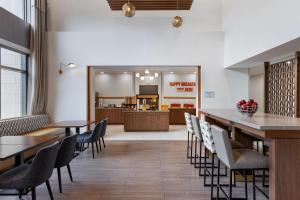 a dining room with tables and chairs and a kitchen at Hampton Inn & Suites by Hilton Windsor in Windsor