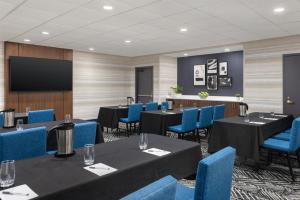 a conference room with tables and blue chairs and a tv at Hampton Inn & Suites by Hilton Windsor in Windsor +41 photos