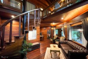 a living room with a couch and a staircase at River tales ริเวอร์เทลส์แก่งกระจาน in Phetchaburi