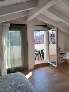 a bedroom with a bed and a balcony with a table at b&b Civico 30 in Lonato