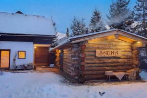 a log cabin in the snow with a sign on it at MountainView Lodge - Sauna, Balkon, 300 m zur Gondel in Sankt Oswald