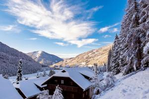 a cabin in the mountains covered in snow at MountainView Lodge - Sauna, Balkon, 300 m zur Gondel in Sankt Oswald