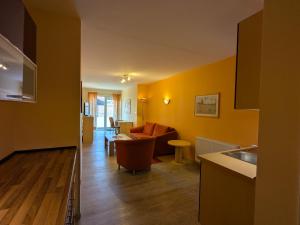 a kitchen and a living room with yellow walls at Suite Hotel Villa Erika in Borkum