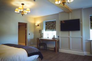 a bedroom with a bed and a desk and a television at The Mill at Conder Green in Conder Green