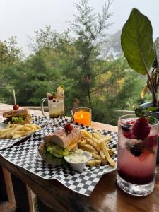 a table with a sandwich and french fries and a drink at Entrecafe Experience- Los Naranjos in Ojo de Agua