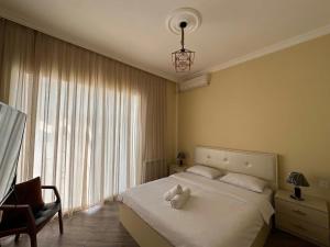 a bedroom with a bed and a chair and a window at Qafqaz Hills Villa in Gabala +19 photos