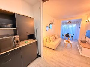 a living room with a tv and a couch and a table at Le Cosy du Lagon bleu in Fréjus