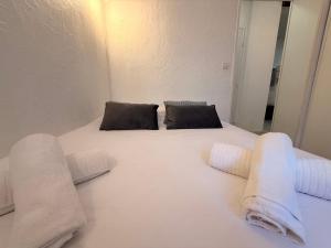 a white bed with two pillows and towels on it at Le Cosy du Lagon bleu in Fréjus +7 photos